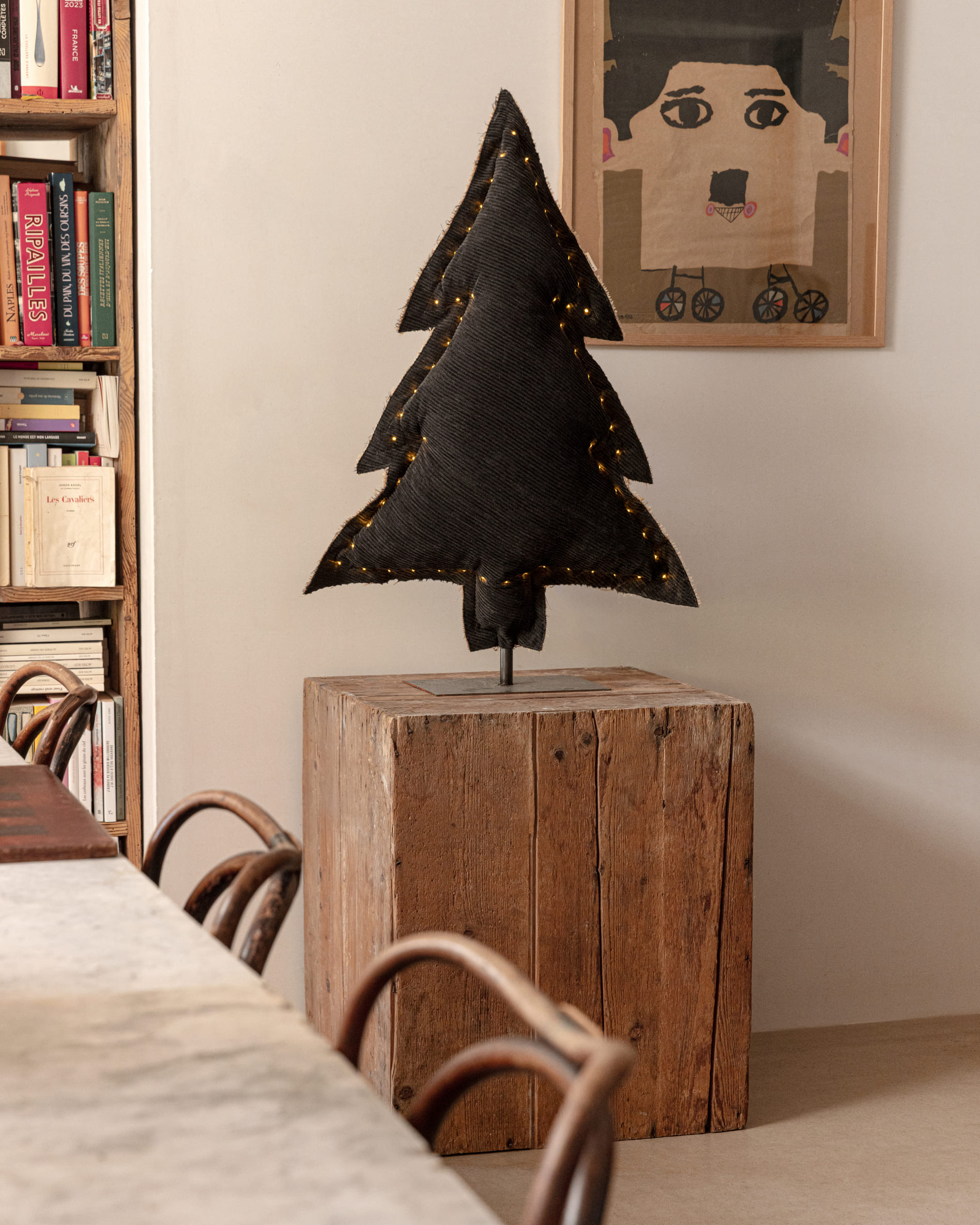 Petit sapin lumineux posé sur un billot de bois